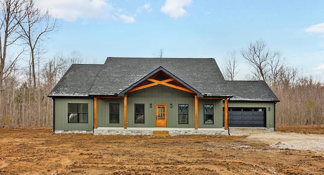 modern farmhouse with dirt driveway and an attached garage