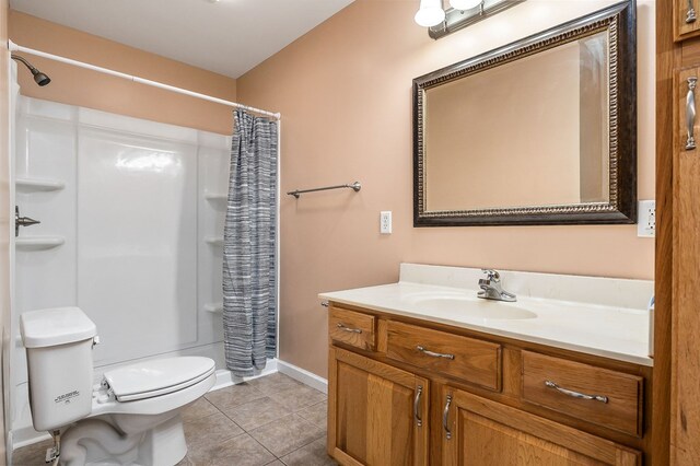 full bath featuring a stall shower, baseboards, toilet, tile patterned floors, and vanity