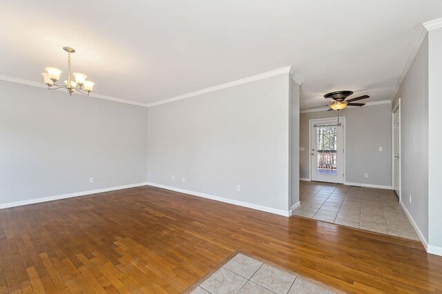 unfurnished room with light wood finished floors, baseboards, ornamental molding, and ceiling fan with notable chandelier