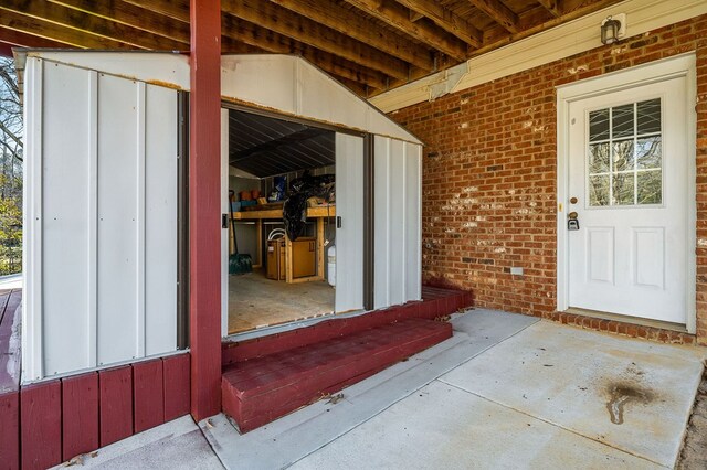 entrance to property featuring brick siding