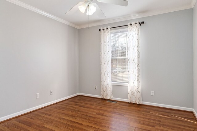 unfurnished room with baseboards, visible vents, wood finished floors, and ornamental molding