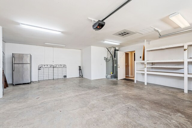 garage with freestanding refrigerator and a garage door opener