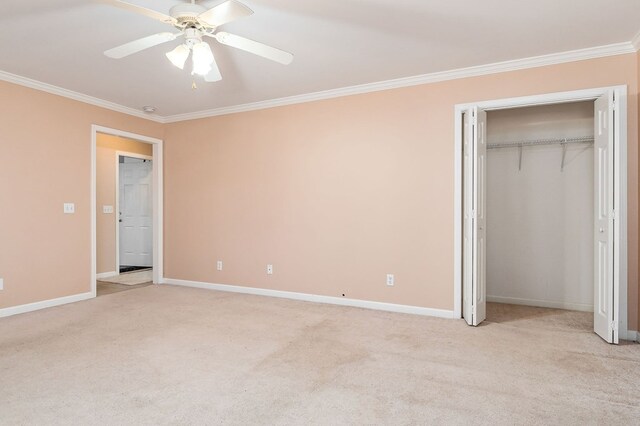 unfurnished bedroom featuring a ceiling fan, baseboards, crown molding, and light colored carpet