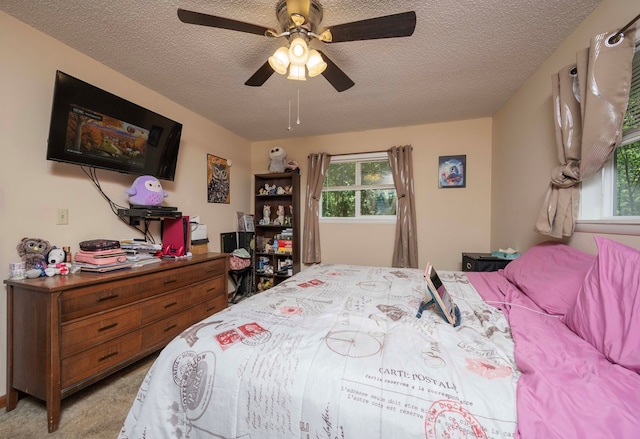 bedroom featuring a ceiling fan, light carpet, and a textured ceiling