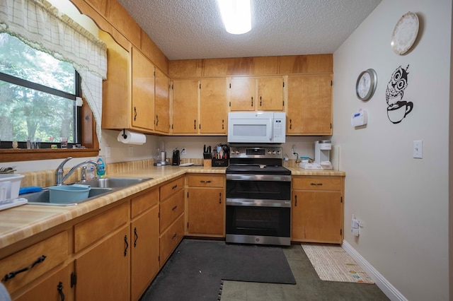 kitchen featuring white microwave, light countertops, a textured ceiling, double oven range, and a sink