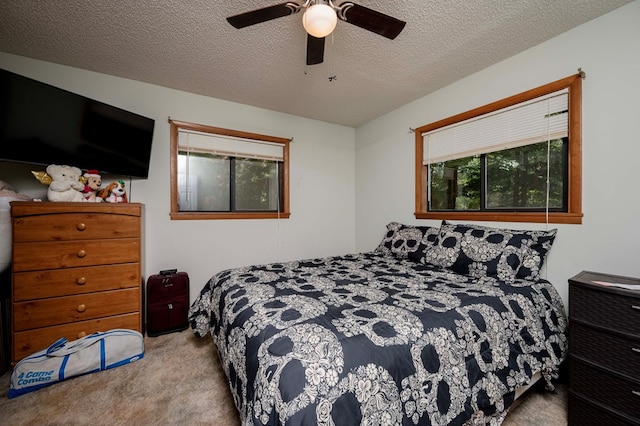 bedroom featuring light carpet, a ceiling fan, and a textured ceiling