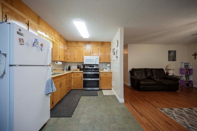 kitchen with open floor plan, light countertops, white appliances, and a textured ceiling