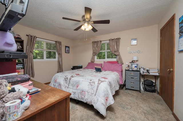 bedroom with light carpet, multiple windows, and a textured ceiling