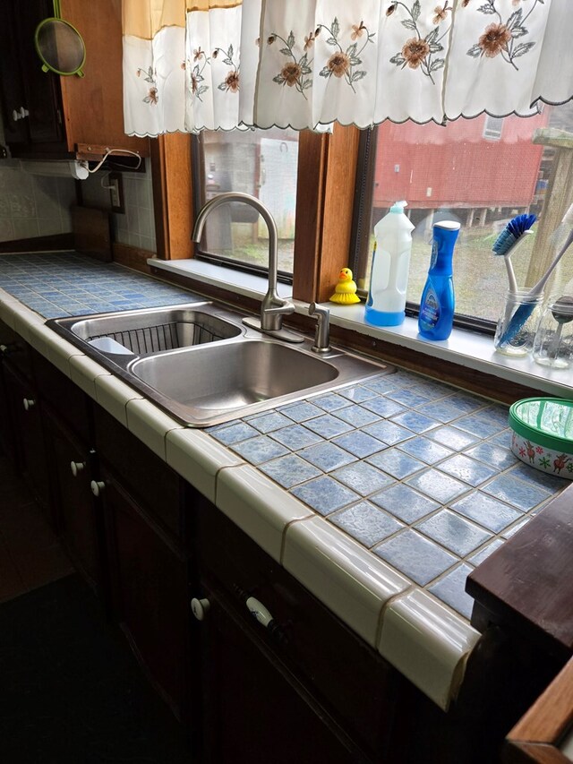 kitchen with tasteful backsplash, a sink, and tile counters