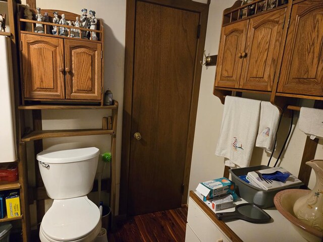 bathroom featuring wood finished floors and toilet