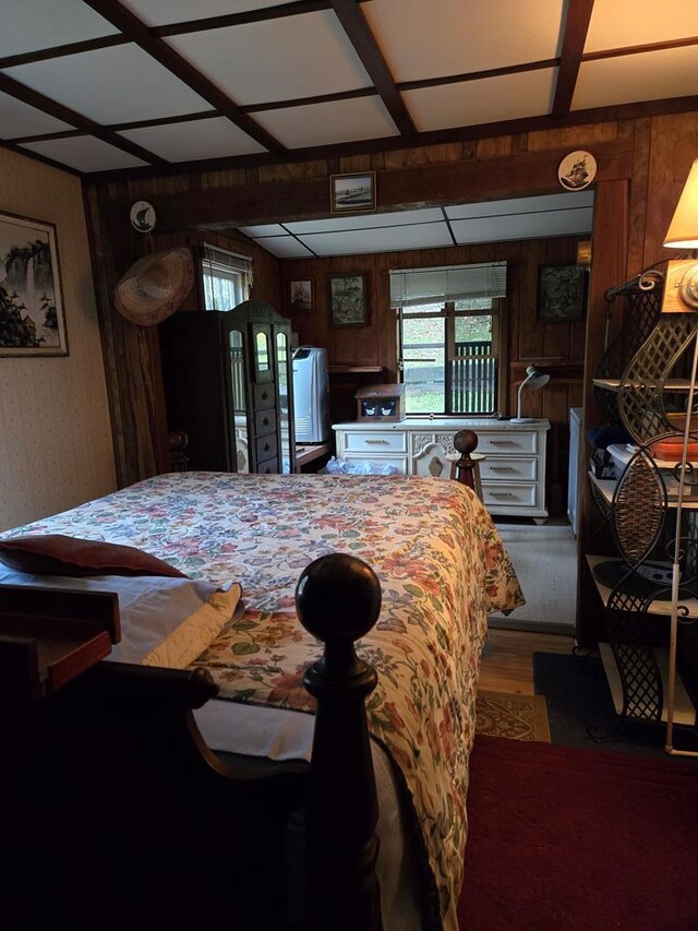 bedroom featuring wood finished floors and wooden walls