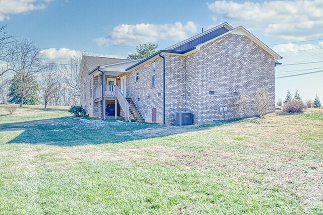 view of home's exterior with brick siding, a lawn, and stairway