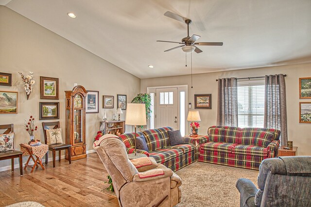 living room featuring baseboards, a ceiling fan, vaulted ceiling, light wood-type flooring, and recessed lighting