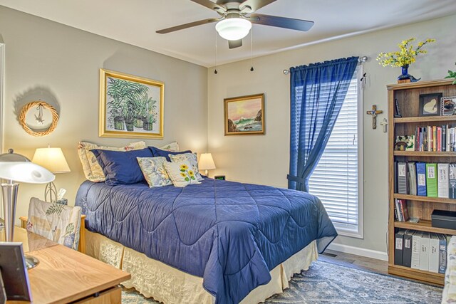 bedroom with ceiling fan, baseboards, and wood finished floors