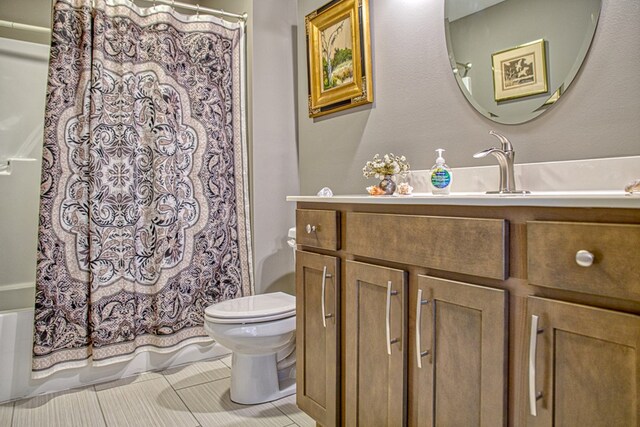 bathroom with toilet, shower / bath combo with shower curtain, vanity, and tile patterned floors