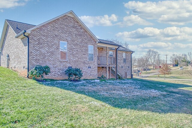 view of side of home with crawl space, stairs, a lawn, and brick siding