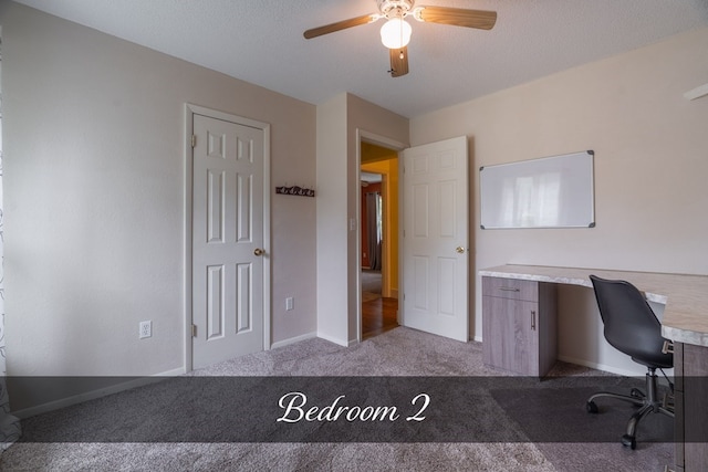 unfurnished office with a textured ceiling, baseboards, a ceiling fan, and light colored carpet