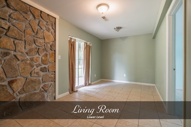 spare room with baseboards, visible vents, and light tile patterned flooring