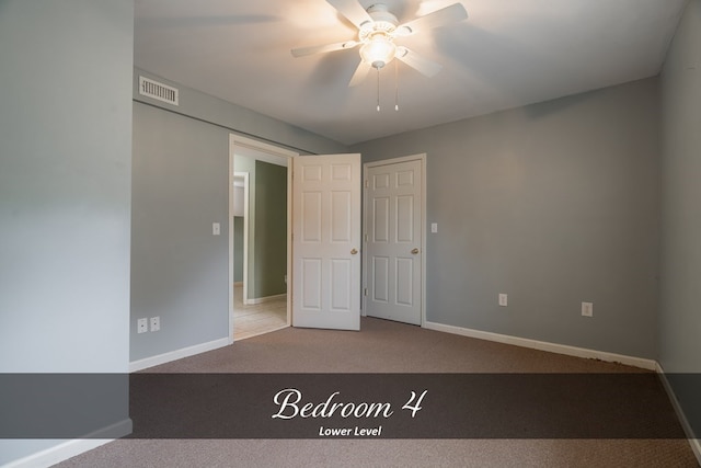 empty room featuring carpet floors, visible vents, ceiling fan, and baseboards