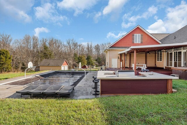 view of swimming pool featuring a hot tub, a patio, and a yard