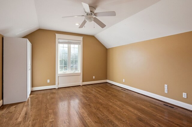 bonus room with lofted ceiling, ceiling fan, wood finished floors, visible vents, and baseboards