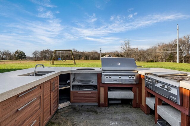 view of patio with area for grilling, grilling area, a playground, and a sink