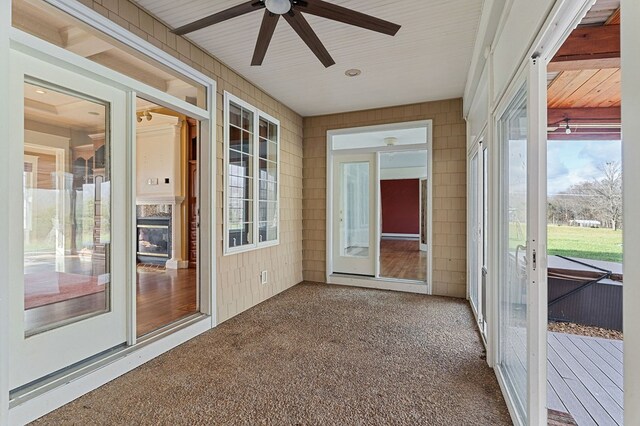 unfurnished sunroom with a healthy amount of sunlight and a ceiling fan