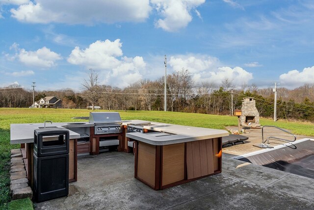 view of patio / terrace featuring exterior fireplace and grilling area