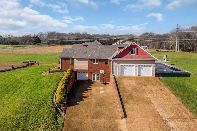 view of front facade featuring concrete driveway, a front lawn, fence, and brick siding