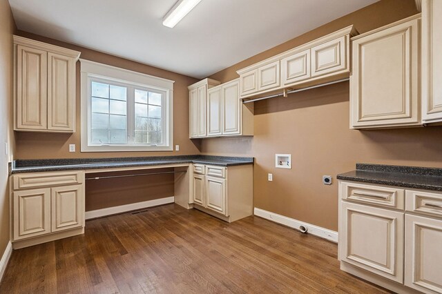 kitchen with cream cabinets, dark countertops, and built in study area