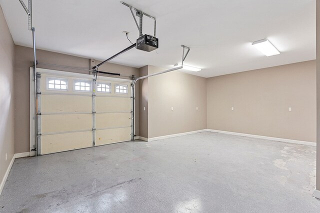 garage featuring a garage door opener and baseboards