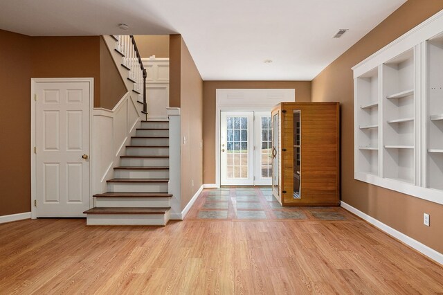 entryway with visible vents, light wood-style flooring, baseboards, and stairs