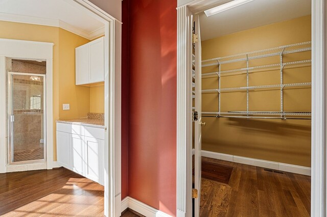 bathroom with ornamental molding, baseboards, and wood finished floors