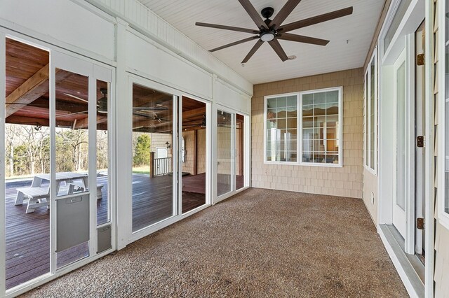 unfurnished sunroom with a ceiling fan