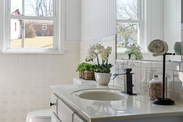 bathroom with vanity, toilet, and a wealth of natural light