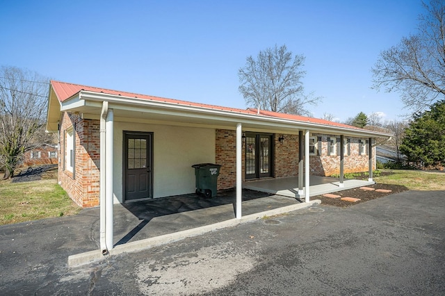 exterior space featuring metal roof and brick siding