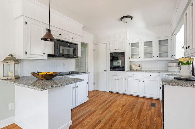 kitchen with white cabinetry, a peninsula, and black appliances