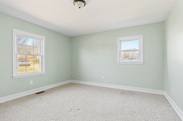 empty room with visible vents, baseboards, and carpet