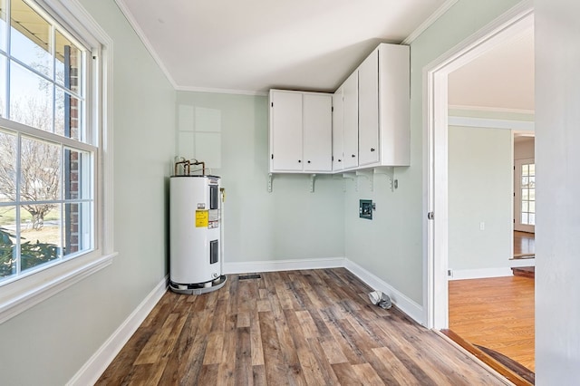 laundry room with dark wood-style floors, cabinet space, electric water heater, and ornamental molding