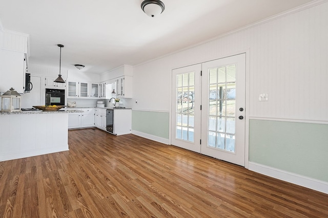 kitchen featuring black appliances, decorative light fixtures, white cabinets, glass insert cabinets, and dark wood-style flooring