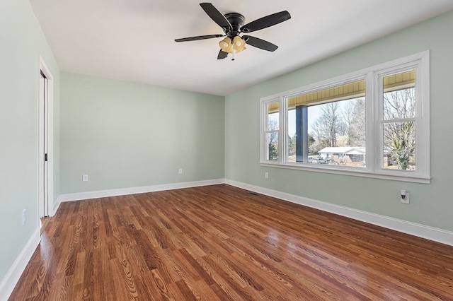 unfurnished room featuring baseboards, wood finished floors, and a ceiling fan