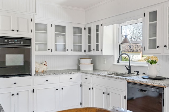 kitchen featuring black appliances, ornamental molding, a sink, white cabinets, and glass insert cabinets