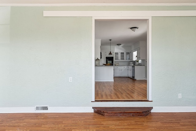 interior space featuring visible vents, dark wood finished floors, and crown molding