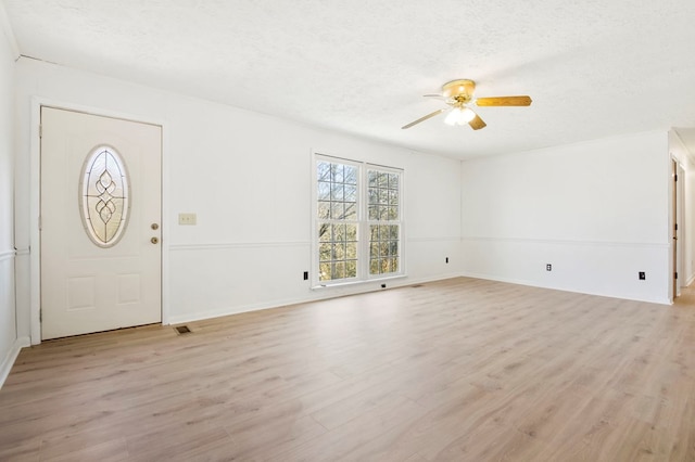 foyer entrance featuring light wood-style floors, a ceiling fan, and a textured ceiling