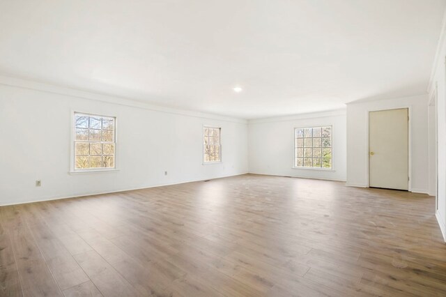 unfurnished room with light wood-style floors and ornamental molding