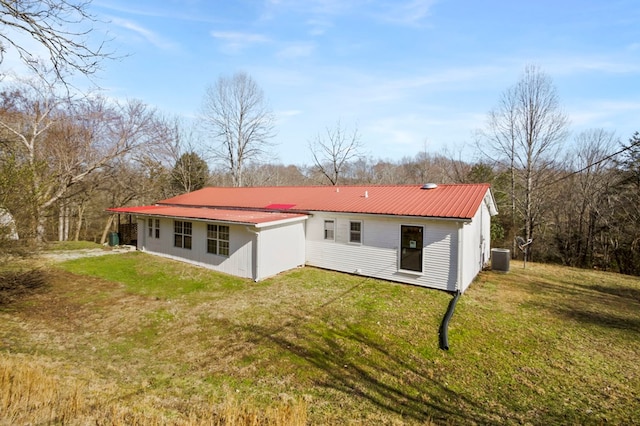 rear view of property featuring metal roof, a yard, and cooling unit