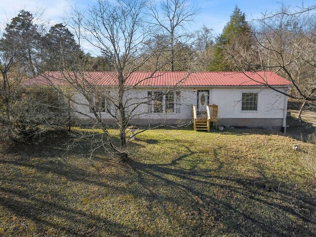 view of front of house with metal roof and a front lawn