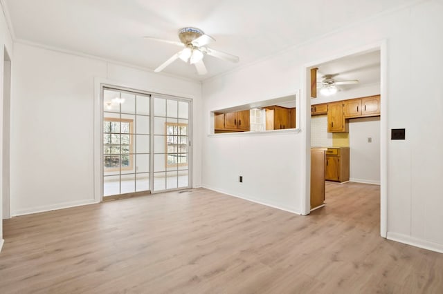 spare room featuring a ceiling fan, crown molding, light wood-style flooring, and baseboards