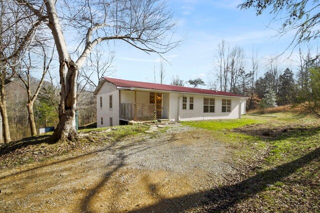 view of front of property featuring driveway and metal roof