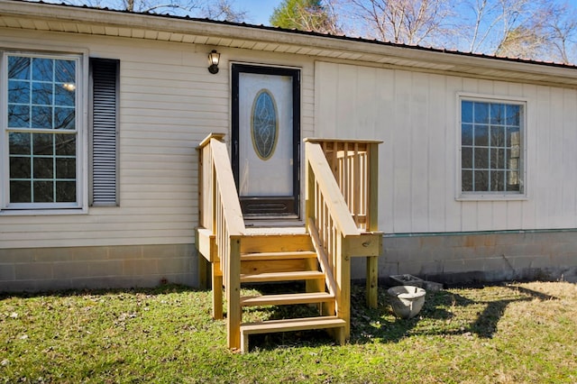 view of exterior entry with metal roof and a lawn